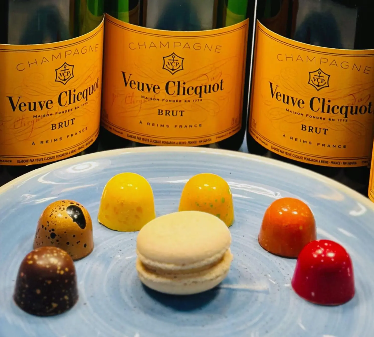 Art Café Orangerie – Café – mehrere Flaschen Veuve Clicquot Brut Yellow Label Champagner und eine Auswahl an Pralinen und ein Macaron